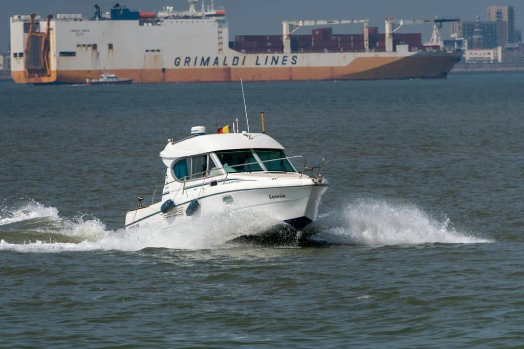 speedboat faster than cargo ship symbolising that small machinery moves faster same as big companies are inefficient
